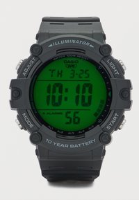 Ψηφιακό ρολόι Casio με στρογγυλή μαύρη θήκη, πράσινη οθόνη LCD και μαύρο λαστιχένιο λουράκι. Διαθέτει αντοχή στο νερό και πέντε συναγερμούς.