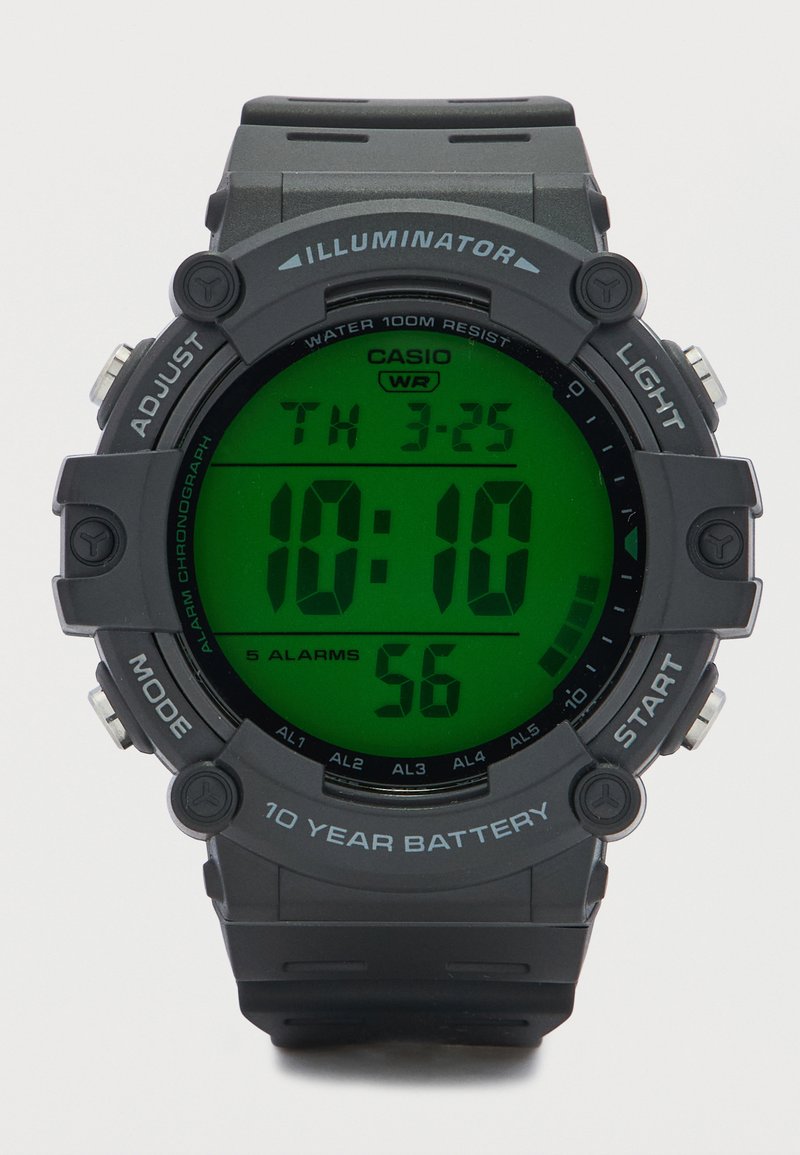 Ψηφιακό ρολόι Casio με στρογγυλή μαύρη θήκη, πράσινη οθόνη LCD και μαύρο λαστιχένιο λουράκι. Διαθέτει αντοχή στο νερό και πέντε συναγερμούς.