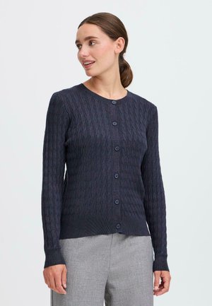 Cardigan en maille bleu marine avec un motif en câble, col rond et fermeture à boutons. Il possède des manches longues avec des poignets et un ourlet côtelés.