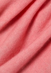 Tissu de laine rose doux et léger avec une texture fine légèrement duveteuse et un motif côtelé subtil, drapé et superposé en plis.