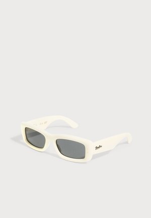 Lunettes de soleil à monture rectangulaire blanche avec des verres foncés et un petit logo noir sur la branche, sur un fond clair uni.