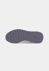 Bežīga sporta apava zole ar teksturētu tumši pelēku gumijas zīmolu un Reebok logo iespiedumu netālu no papēža.