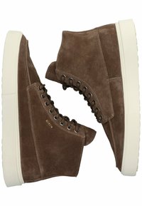 Bruine suède high-top sneakers met witte rubberen zolen, voorzien van zilveren oogjes en veters, en een gouden merkteken aan de zijkant.