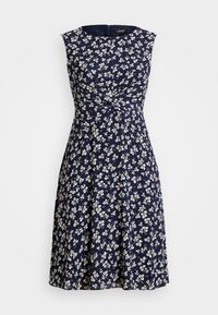 Ärmlös marinblå klänning med blommönster i krämfärgad, en figursydd överdel med en tvistdetalj vid midjan och en utsvängd kjol.