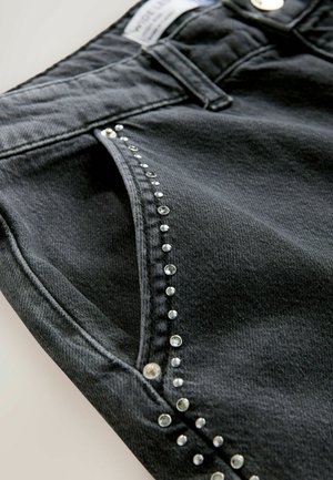 Sorte denim shorts med en dekorativ række af klare rhinsten langs lommens søm, med en glat tekstur og tætsiddende design.