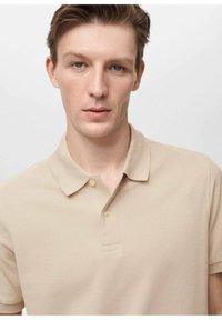 Beige polo shirt med en klassisk krave, to-knap lukning og tekstureret stof. Korte ærmer og en afslappet pasform.