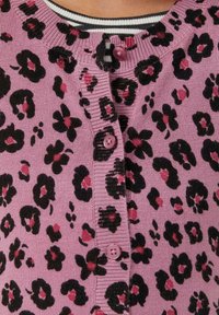 Rosa Strickjacke mit einem schwarz und dunkelrosa Leopardenmuster, ausgestattet mit fünf Knöpfen vorne und einem gerippten Ausschnitt. Weiche Stricktextur.