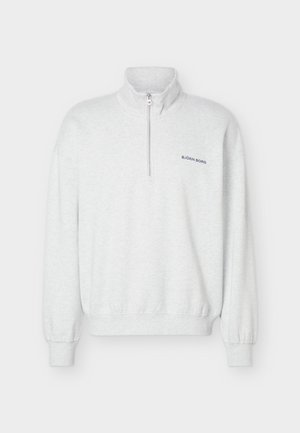 Helehall neljandiku lukuga dressipluus kõrge krae, elastsete varrukaservade ja alumise servaga ning väikese "BJÖRN BORG" logoga vasakul rinnal.