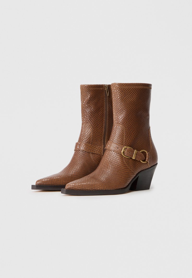 Braune, schlangenmusterierte Lederan.bootstrap mit spitzer Zehenpartie, seitlichem Reißverschluss und einem Schnallenakzent. Mit niedrigem, gestapeltem Absatz.