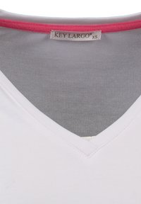 Witte V-hals T-shirt van gladde stof, met een roze bies bij de halslijn en een label dat zegt "KEY LARGO XS."