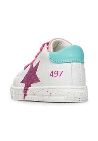 Sneaker bianco con un design a fulmine glitterato rosa, tallone turchese, lacci rosa e suola maculata. Numero "497" sul tallone.