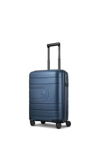 Valise rigide bleue avec poignée télescopique et quatre roues pivotantes, debout sur fond blanc.