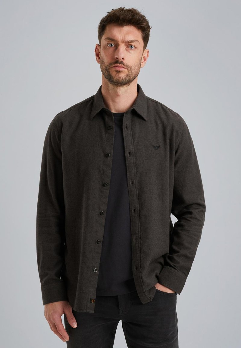Donkergrijze button-up shirt met een kraag, gemaakt van textiele stof, gecombineerd met een zwart T-shirt eronder, gedragen met zwarte spijkerbroeken.