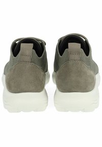 Scarpe da ginnastica grigio-verdi con tomaia in suede e tessuto testurizzato. Le suole in gomma presentano un intersuola bianca e un'etichetta sul tallone.