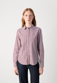 Camicia a strisce rossa e bianca, in cotone, colletto button-down, maniche lunghe, orlo curvo, con un piccolo logo sul petto.