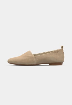 Ballerine in suede beige con punta rotonda, design minimalista, suola piatta e tacco basso. Presentano un'etichetta sul tallone per una facile vestibilità.