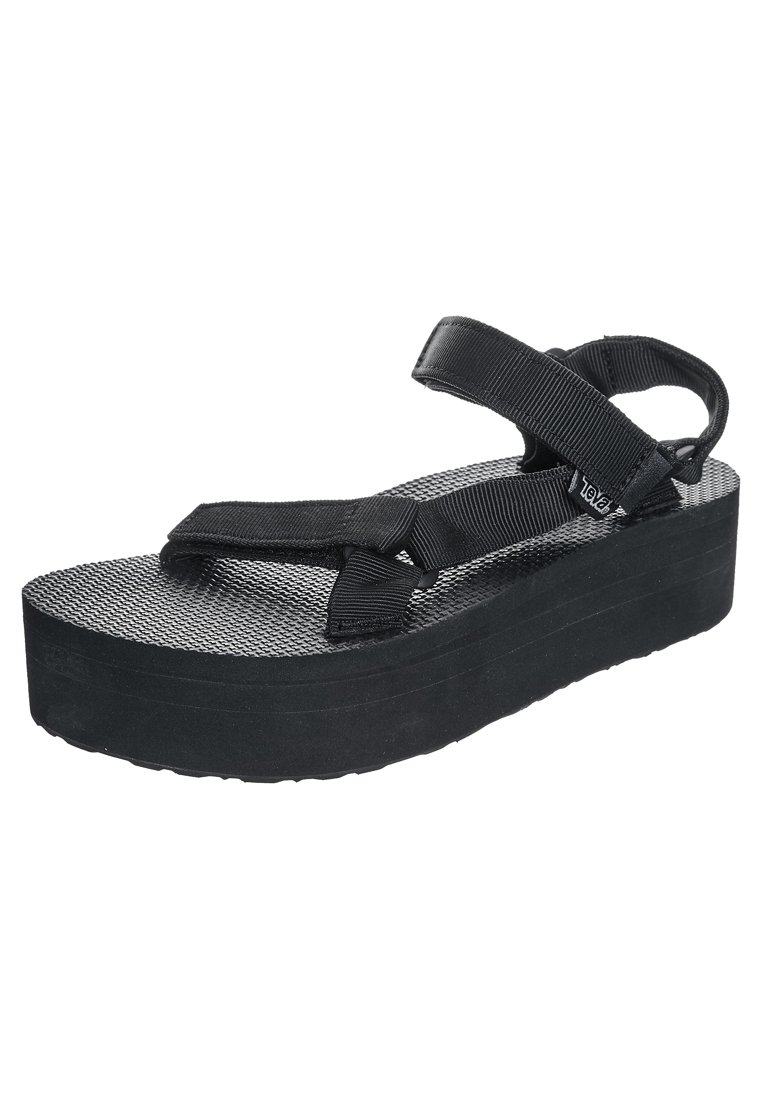 Black platform sandals with textured rubber sole and fabric straps. Adjustable ankle and toe straps for secure fit. Lightweight and minimal design.