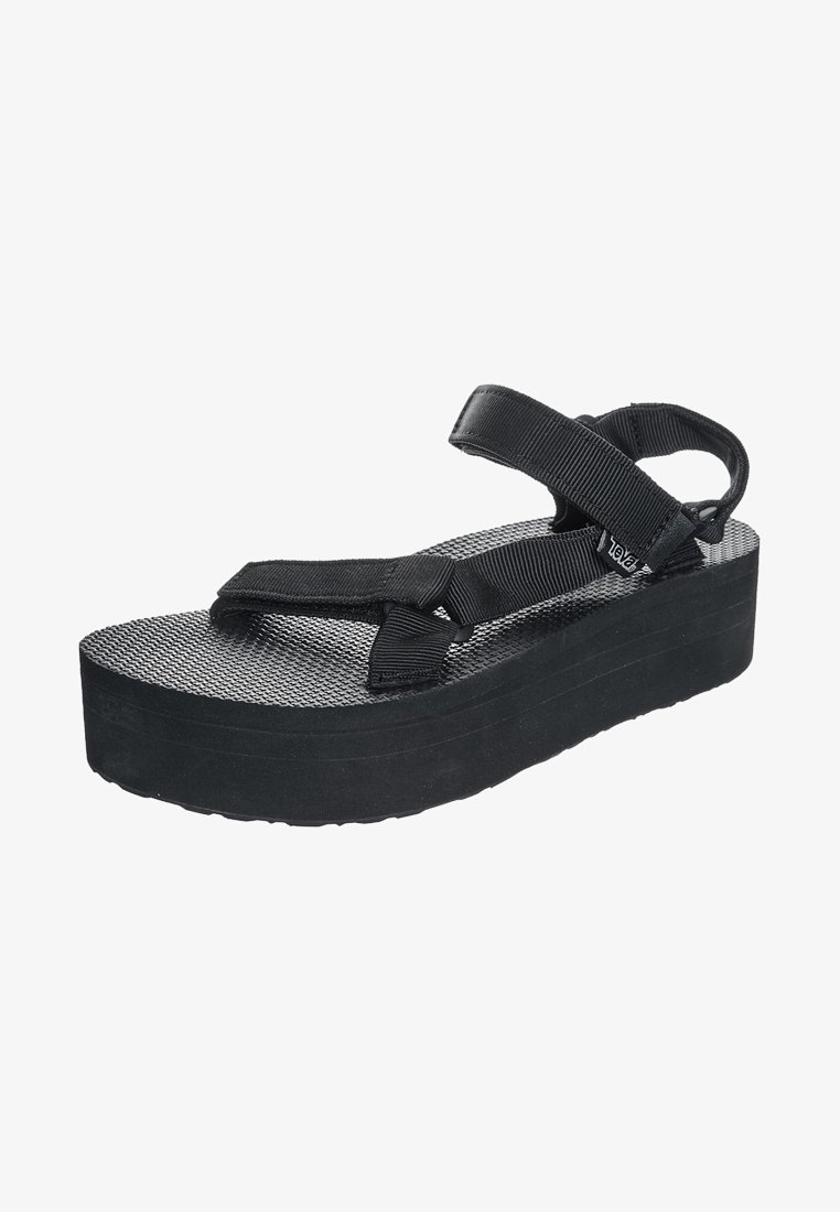 Black platform sandals with textured rubber sole and fabric straps. Adjustable ankle and toe straps for secure fit. Lightweight and minimal design.