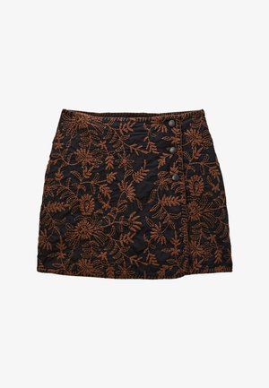 Jupe noire brodée avec des motifs floraux bruns complexes, deux boutons sur le côté et une finition en tissu texturé.