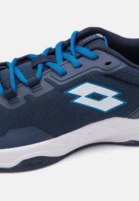 Ténis de desporto azul-marinho com tecido texturizado, atacadores azuis e um logótipo branco; apresentam uma sola almofadada e acentos de design angulares.