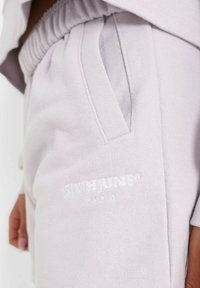 Ljuslila sweatpants i mjukt tyg, med elastisk midja, sidofickor och präglad logotypdetalj.