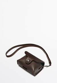 Custodia per cellulare in pelle marrone con chiusura a scatto, bordi arrotondati e una tracolla removibile per un facile trasporto. Presenta lievi dettagli di texture.