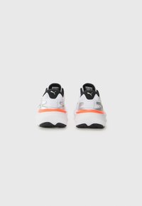 Sneaker bianche con tallone e dettagli neri, caratterizzate da un'intersuola arancione vivace e pannelli in mesh texturizzato. Il marchio è visibile sui lati.