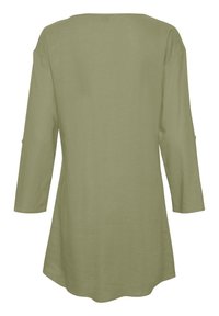 Dolga majica iz olivno zelene lanene tkanine s krojem na jamo, ima sproščen kroj in zaobljen rob. Vključuje gumbe na rokavih.