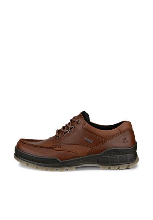 Zapato casual marrón de cuero con cordones, cuello acolchado negro y suela negra gruesa con patrón de dibujo.