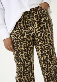 Leopardprint broek in beige en zwart, met een ontspannen pasvorm en denim materiaal met een voelbare textuur en een vijf-pocket ontwerp.