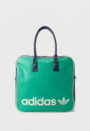 Πράσινη και ναυτική τσάντα tote Adidas με λευκό λογότυπο και ναυτικά χερούλια σε απλό λευκό φόντο.