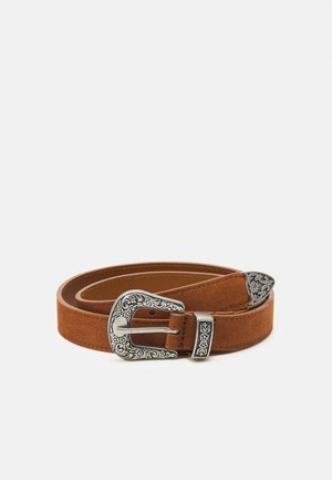 Ceinture en daim marron enroulée avec boucle, passant et embout en argent ornés de gravures florales, sur fond blanc uni.
