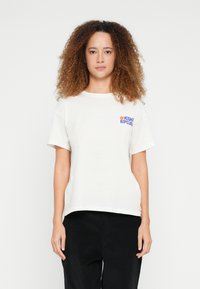 Bomulds-T-shirt i off-white med rund halsudskæring. Har blå og orange grafisk tekst på venstre brystområde. Korte ærmer, afslappet pasform.