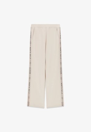 Pantaloni beige a gamba larga con vita elastica, tasche laterali e scritta "GUESS NORTH SAILS" che corre verticalmente lungo entrambe le gambe.