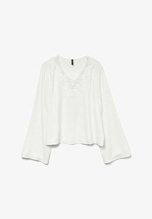 Blouse blanche avec une finition texturée, décolleté en V et broderie florale sur la poitrine. Dispose de manches longues et larges ainsi qu'un ourlet court.