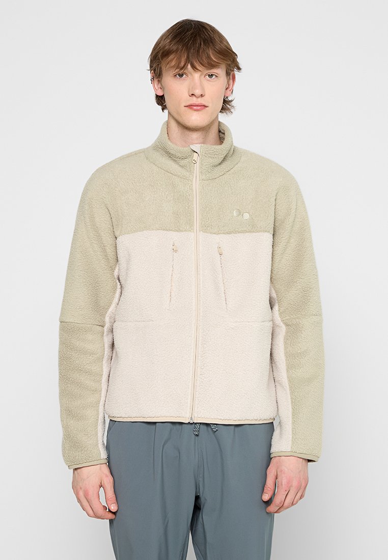 Fleecejacke mit Frontreißverschluss, im zweifarbigen Design in hellbeige und blassgrün, und zwei mit Reißverschluss versehenen Fronttaschen.