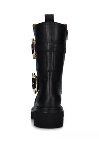Stivale in pelle nera fino al ginocchio con suola spessa, dettagli in metallo dorato e zip posteriore. Presenta fascette con fibbie sul lato esterno.