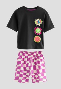 Schwarzes Baumwoll-T-Shirt mit bunten Grafikdesigns und kurzen Ärmeln, kombiniert mit weißen Shorts, die ein großes rosa-weißes Karomuster aufweisen.