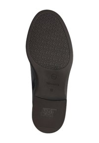 Semelle de chaussure noire avec une surface texturée, présentant un motif circulaire et un léger rebord pour l'adhérence. La marque indique "Tamaris" et "ANTI SLIDE."