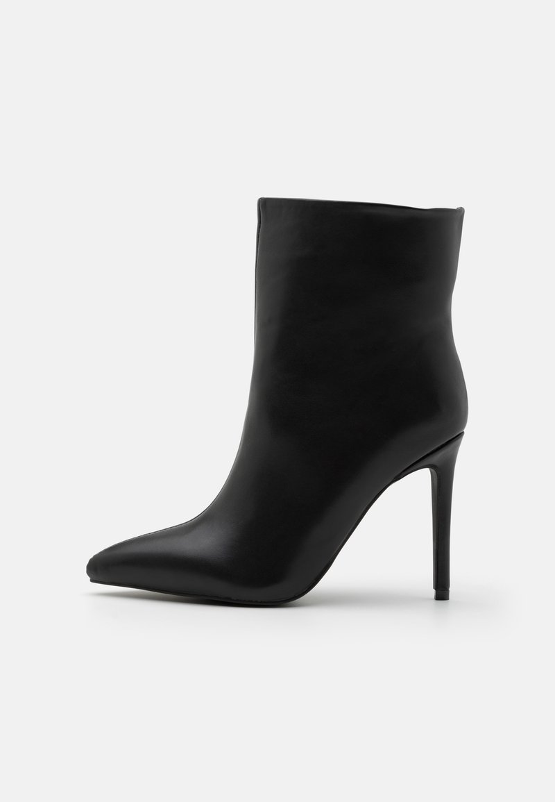 Bottine en cuir noir à bout pointu avec talon stiletto fin, finition lisse et tige de hauteur moyenne sur fond uni.
