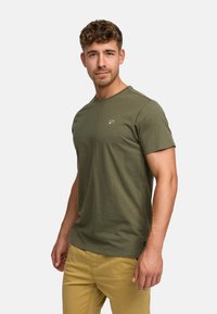 Dark green cotton t-shirt with short sleeves, crew neckline, and a small logo detail on the chest. Simple design, lightweight fabric.