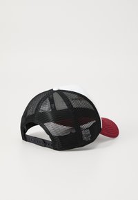 Rote und weiße Baseballmütze mit einem Rücken aus Kunststoffnetz und verstellbarem Riemen. Gebogener Schirm, einfarbige Vorderseite und Netzdetails.