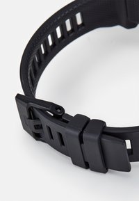Schwarzes Silikon-Uhrenarmband mit strukturiertem Oberflächen, verstellbar mit einer strapazierfähigen Schnalle und Ausschnitten für Belüftung und Flexibilität.