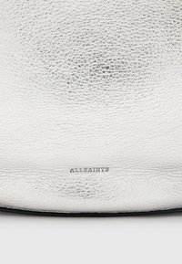 Borsa in pelle argento con superficie testurizzata, caratterizzata da un sottile branding in lettere embossate. Design semplice e moderno con una forma elegante.