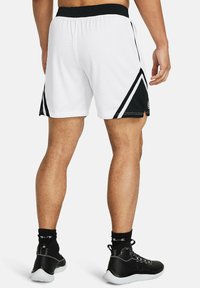 Hvide atletiske shorts med sorte detaljer, netstof, elastisk taljebånd og sidestriber. Båret med sorte sneakers og sokker.