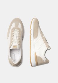 Las zapatillas de ante beige y cuero blanco presentan una puntera redonda, diseño de cordones y suela de goma beige con acentos texturizados.