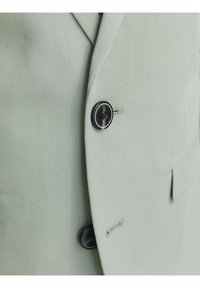 Jasnozielony żakiet o gładkiej teksturze, z pojedynczym czarnym guzikiem i starannie wykończonym kołnierzem.