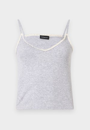 Pilka raukšlėta marškinė su reguliuojamomis spaghetti petnešomis. Yra v-formos iškirptė ir nelygus kreminių atspalvių apipjaustymas aplink kraštus.