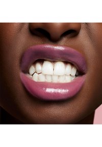 Close-up van lippen met een glanzende, gedempte mauve kleur; tanden zijn helder wit; huidskleur is diep bruin, met een gladde textuur en natuurlijke contour.