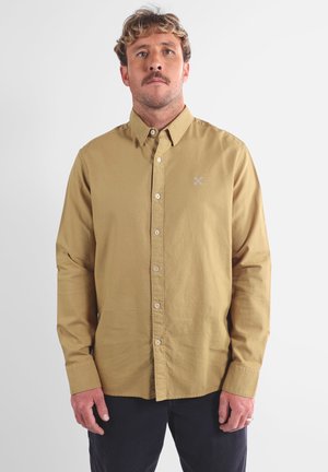 Chemise boutonnée kaki, en coton, à manches longues, patte de boutonnage à l'avant, broderie du logo sur la poitrine, col classique, coupe décontractée.